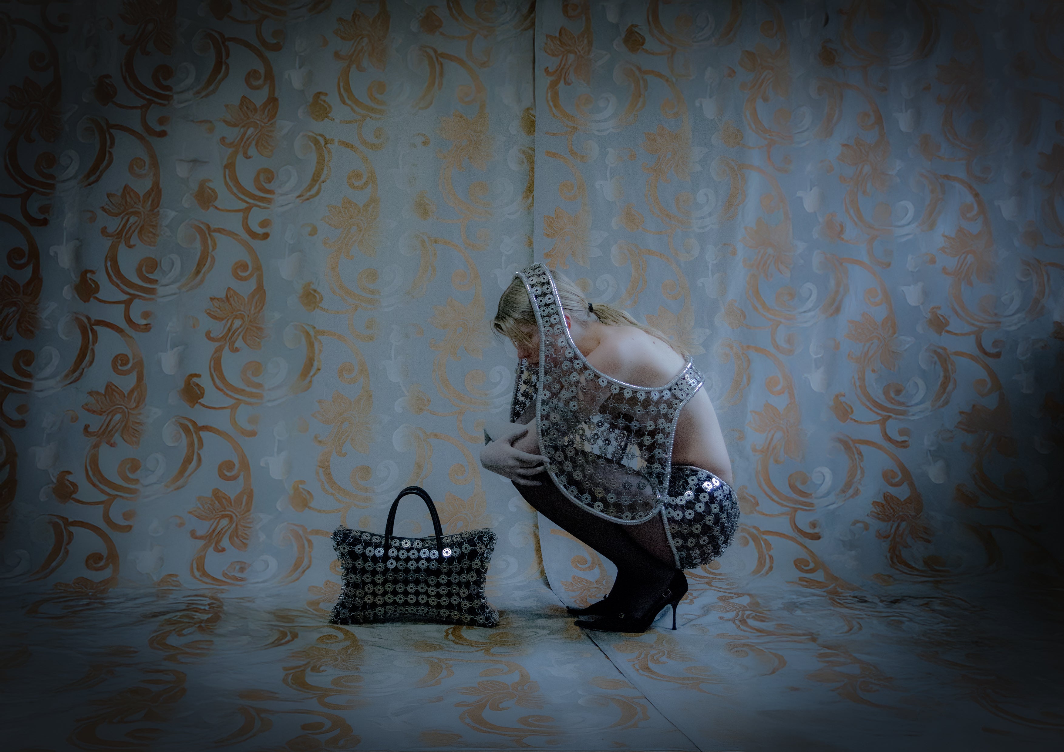 Person in sparkling outfit with matching handbag against ornate wallpaper