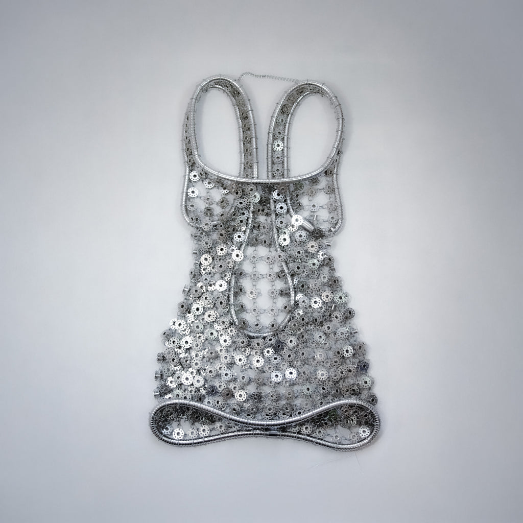 silver short dress out of bobbins on a light gray background 