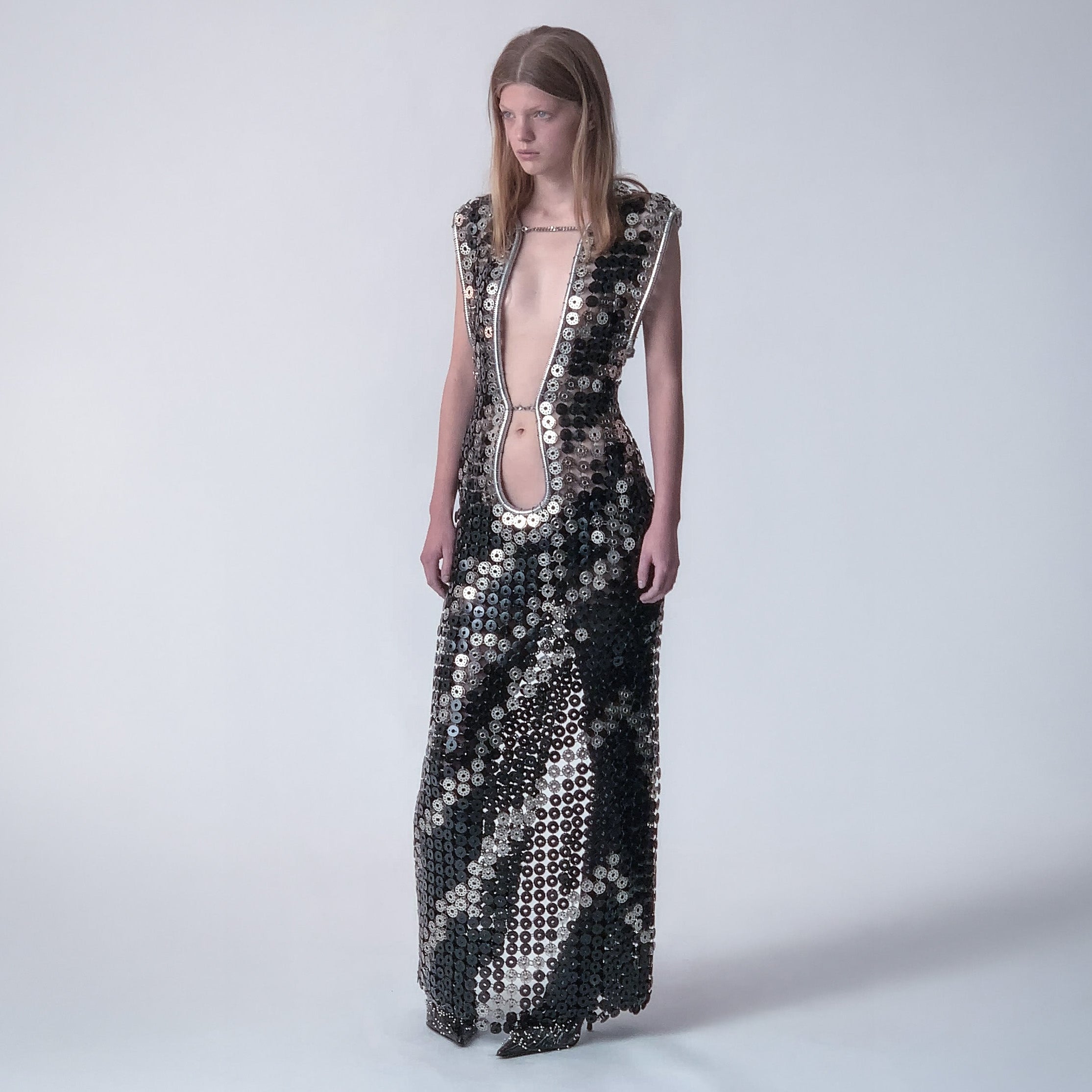 person wearing a long dress out of black and metallic  bobbins in a zebra pattern on a light gray background 